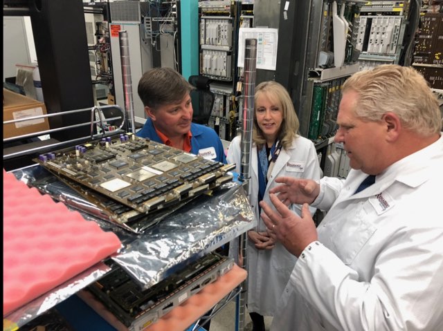 Renaissance CEO Len Anderson going over hardware parts with Premier Doug Ford and MP Merrilee Fullerton.