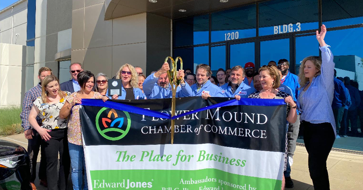 Group picture with ribbon cutting to reveal Renaissance's joining of the Flower Mound Chamber of Commerce.